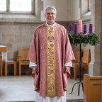 A priest wearing the rose Gaudete chasuble with gold rose-vine orphrey beside an Advent wreath with the rose candle
