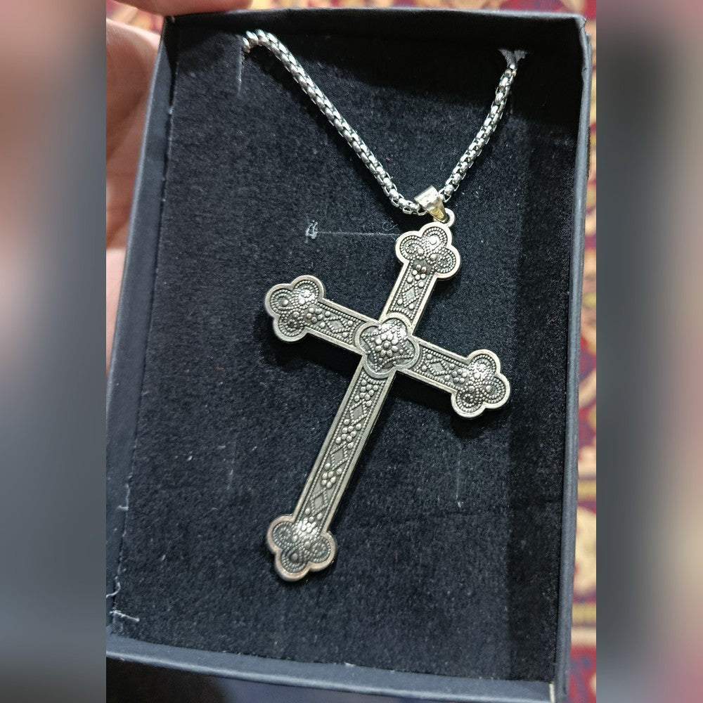Silver-tone cross pendant with trefoil arm ends and a beaded, granulated face, on a box chain, lying in a black gift box