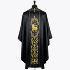 Back of the black chasuble showing the gold Agnus Dei in a gothic arch above a column of fleur-de-lys scrollwork