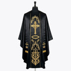Front of a black gothic chasuble, the gold orphrey embroidered with a flowering cross, a crown of thorns and an INRI cross, shown with a matching black and gold stole