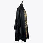 Side view of the black satin chasuble showing the full gothic drape falling over the arm