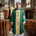 A priest wearing the green Celtic cross chasuble standing in the centre aisle of a church with stained glass behind him