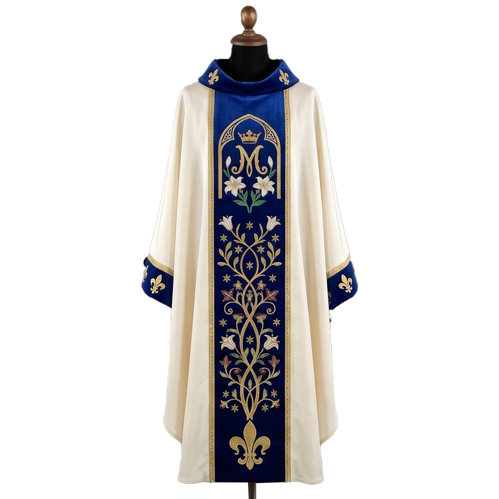 Front of an ivory chasuble with a royal blue velvet orphrey embroidered with a crowned Marian M, white lilies, a flowering vine and a gold fleur-de-lys