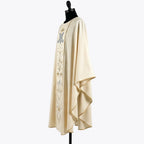 Side view of the ivory Marian chasuble showing the gold piped hem and the soft gothic drape over the arm