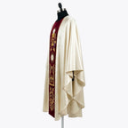 Side view of the ivory satin chasuble showing the burgundy velvet orphrey and the deep gothic drape