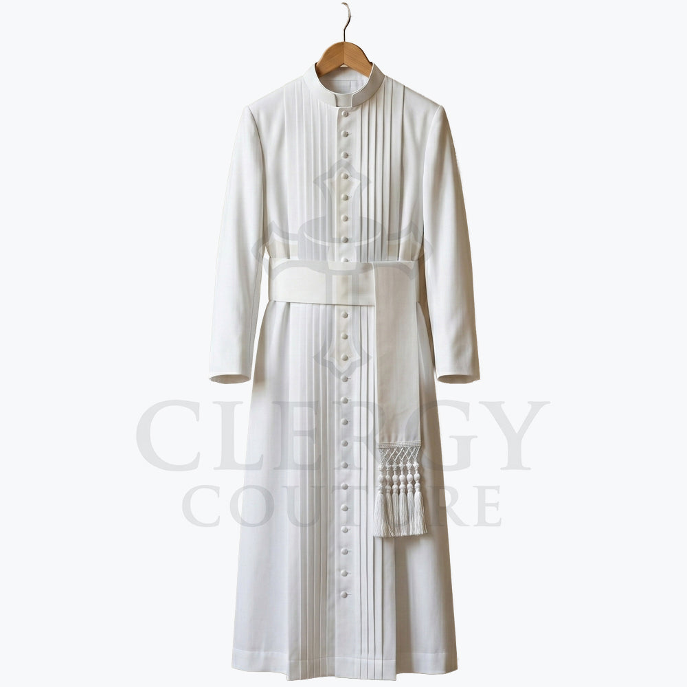 Front view of a white clergy cassock robe on a hanger, showing the narrow pleated front panel and the fringed sash belt.